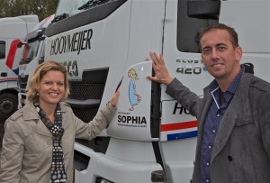 Mendy Verburg van de stichting Vrienden van Sophia en Marco de Groot bij de nieuwe reclame op de trucks