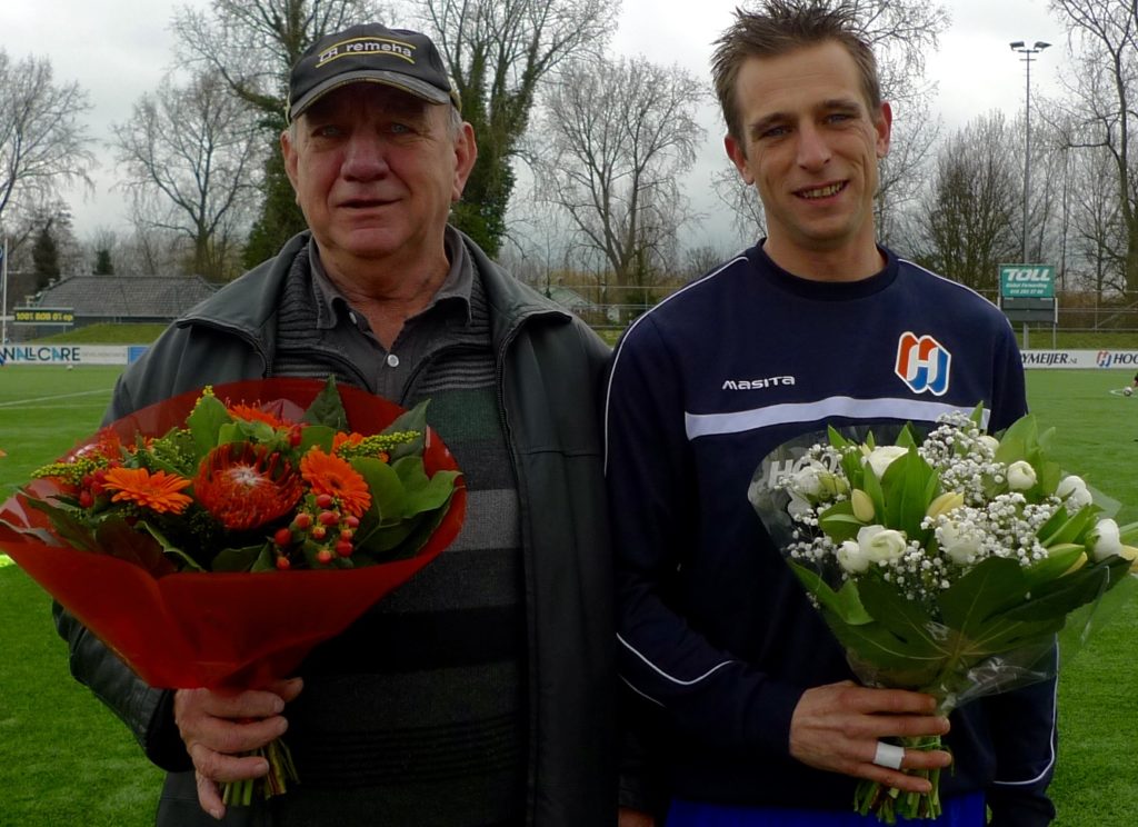 Vader Henk (l.) en zoon Michael Rijgersberg, met bloemen vlak voor de wedstrijd van VDL 1